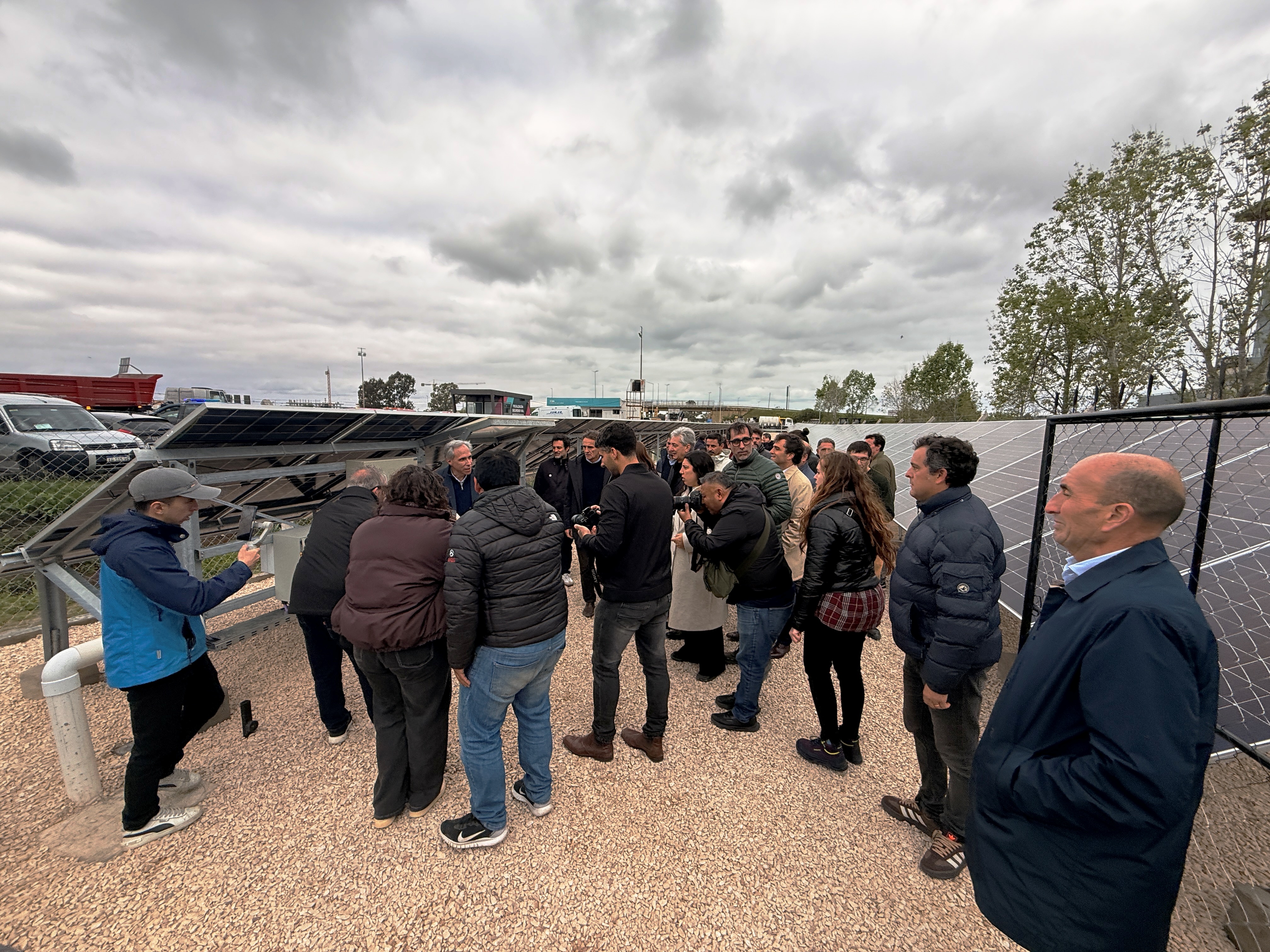 “El personal de AUBASA recorre el parque solar en la inauguración: 93 metros de campo fotovoltaico con piedra blanca entre las filas para maximizar el rendimiento bifacial.”