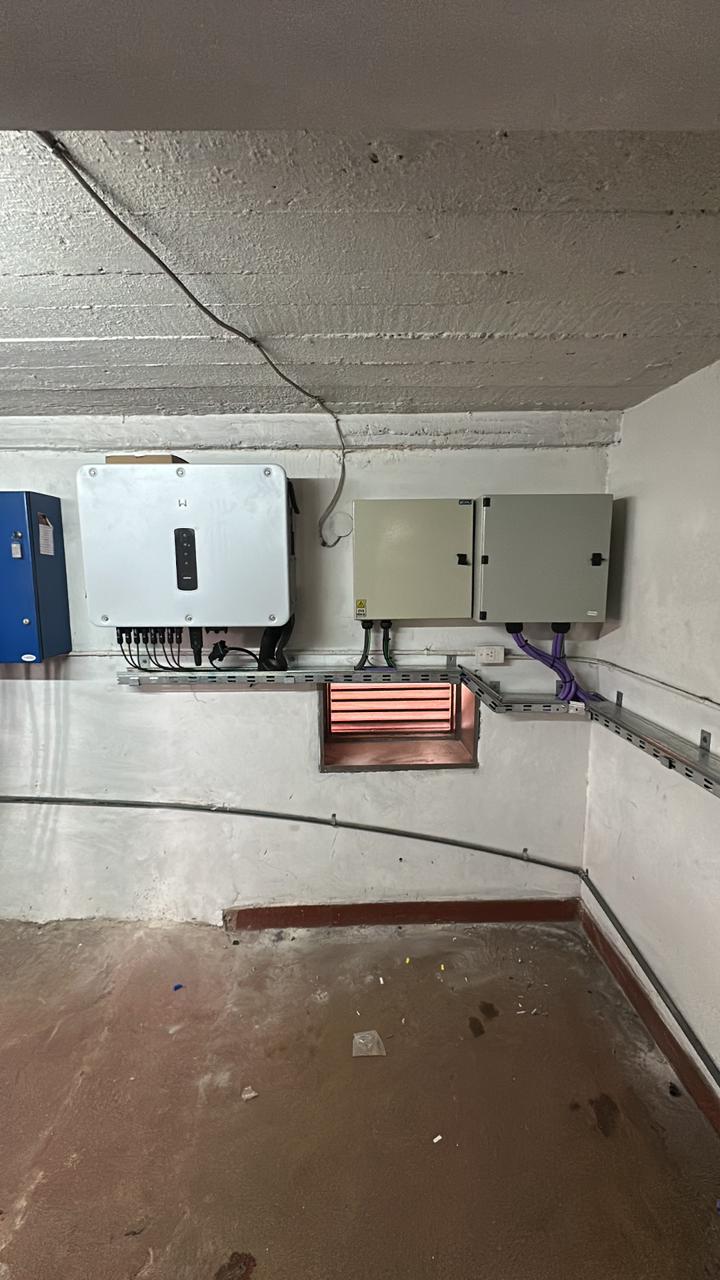Inversor Goodwe de 80 kW con tableros DC y AC en sala técnica interior: protección mecánica y eléctrica para un sistema que opera en un edificio escolar activo.
